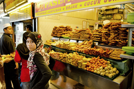 veiled muslim girl at snack stand in penang malaysia