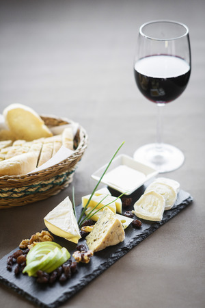 mixed french cheese platter with red wine glass and breadの写真素材