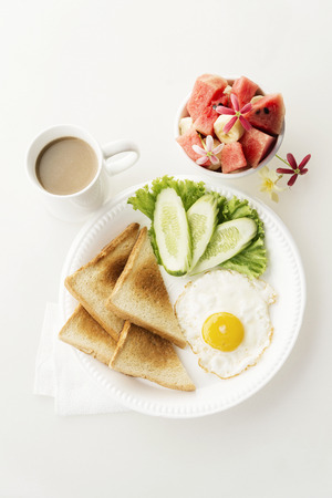 egg salad toast fruit and coffee breakfast set on white backgroundの写真素材