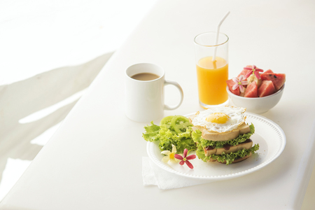 egg and salad sandwich with fruit salad juice and coffee breakfast setの写真素材