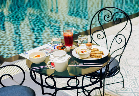 gourmet continental breakfast table set at luxury hotel poolside