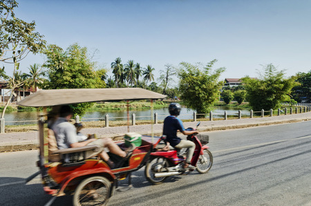 asian tuk tuk taxi on street by riverside of siem reap city cambodiaのeditorial素材