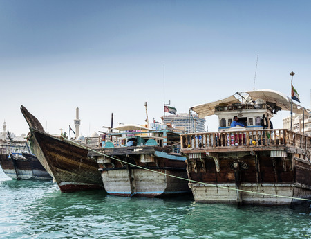traditional old arabian wood dhow boats in deira harbour of dubai port UAEのeditorial素材