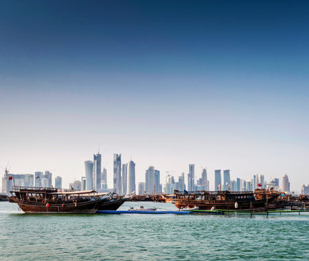 doha city skyscrapers urban skyline view and dhow boat in qatar