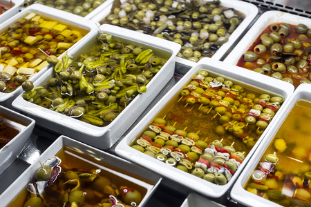mixed olive tapas snacks in la boqueria market display trays in barcelona spainの写真素材
