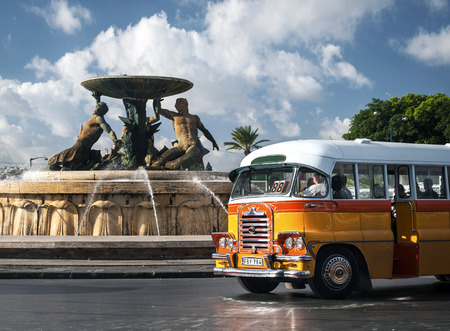 vintage orange british bedford buses on street of la valletta old town maltaのeditorial素材
