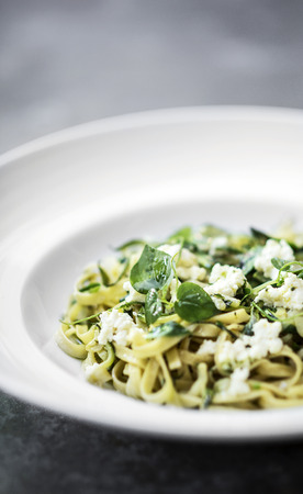 gourmet organic italian ricotta and fresh mixed herbs tagliatelle on plateの写真素材