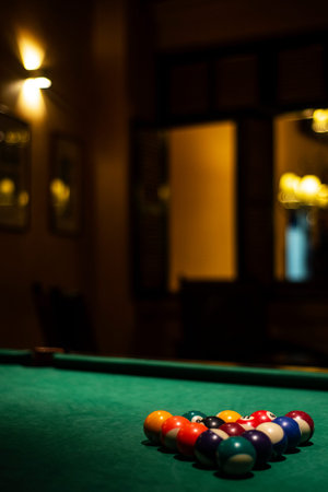 billiards balls on pool table in cozy dark bar interior detail