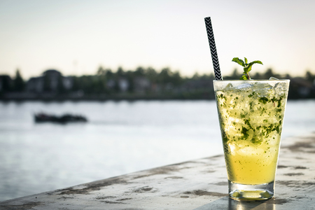 orange mojito summer cocktail drink on outdoor riverside bar tabeの写真素材