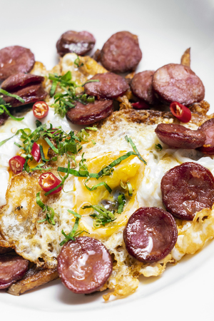 spicy chorizo sausage and eggs spanish huevos rotos with fries tapas snackの写真素材