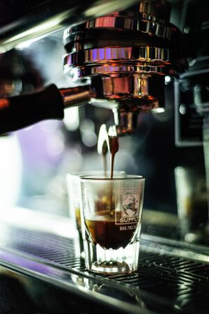 making espresso coffee close up detail with glasses and modern cafe machineのeditorial素材