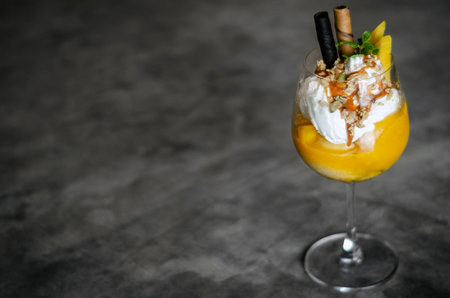 organic mango and passion fruit tropical ice cream sundae in wine glassの写真素材