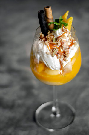 organic mango and passion fruit tropical ice cream sundae in wine glass