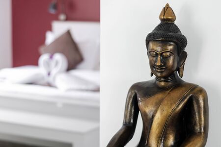 bronze buddha statue interior design detail in modern asian home living roomの写真素材
