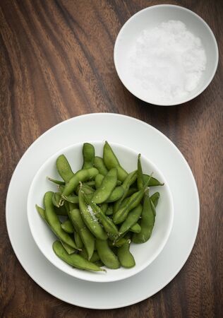 organic edamame beans snack in bowl on table with sea saltの写真素材