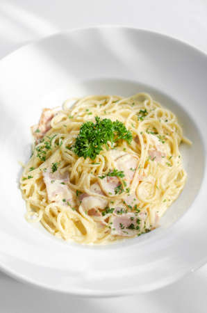 spaghetti carbonara italian pasta dish on white table backgroundの写真素材