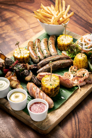 organic mixed grill barbecue meat platter rustic set meal with sausages, skewers, side dishes and saucesの写真素材