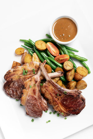 australian organic lamb chops with vegetables and gravy meal on white background