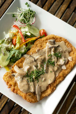 german veal Jagerschnitzel schnitzel cutlet with mushroom sauce and saladの写真素材