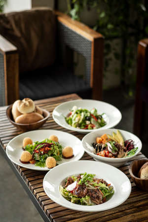 several different fresh mixed salad dishes on restaurant tableの写真素材