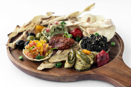 vegan tapas snacks sharing wood board platter on white backgroundの写真素材