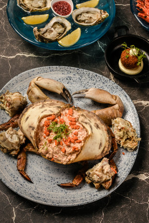 Sapateira Recheada traditional Portuguese stuffed crab meal with mixed seafood side dishes on gourmet restaurant indoors table in Lisbon Portugalの写真素材