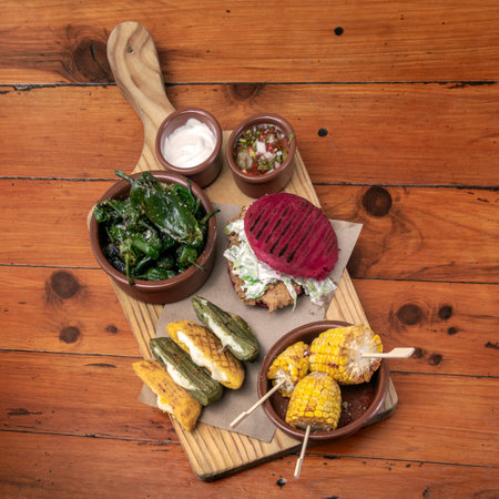 mixed traditional colombian and venezuelan snack food platter on wooden restaurant tableの写真素材