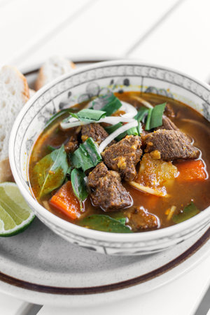 Bo Kho spicy traditional vietnamese beef and vegetable stew on white table in da nang vietnam...
