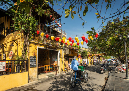 HOI AN, VIETNAM - FEBRUARY 8 2026: hoi an old town tourist area street with cyclo bicycle richshaws in vietnam on sunny dayのeditorial素材