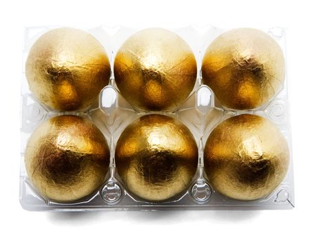 Six golden eggs in an egg carton isolated over whiteの写真素材