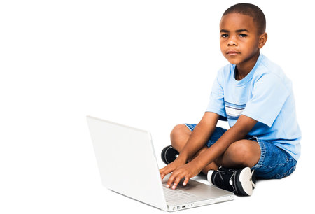 Portrait of a boy working on a laptop isolated over white