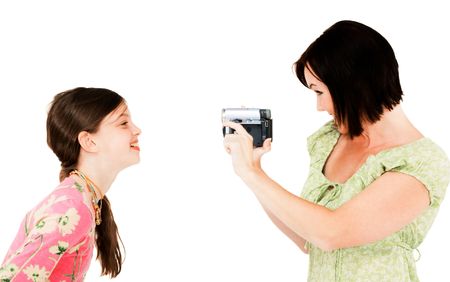Woman filming a girl with a home video camera isolated over whiteの写真素材