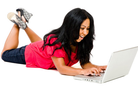 Mid adult woman using a laptop and smiling isolated over whiteの写真素材