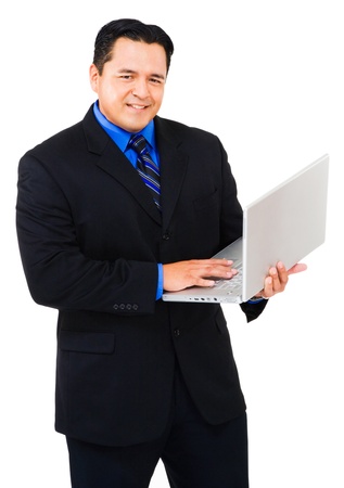 Portrait of a businessman using a laptop and smiling isolated over whiteの写真素材