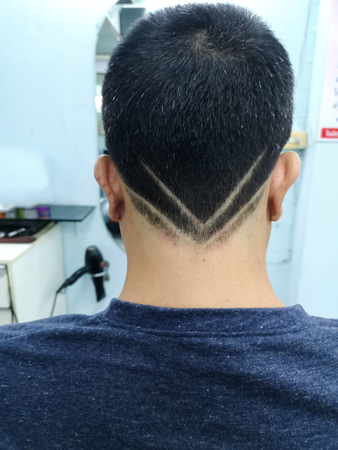 Young man with short hair design isolated on black from back.の写真素材