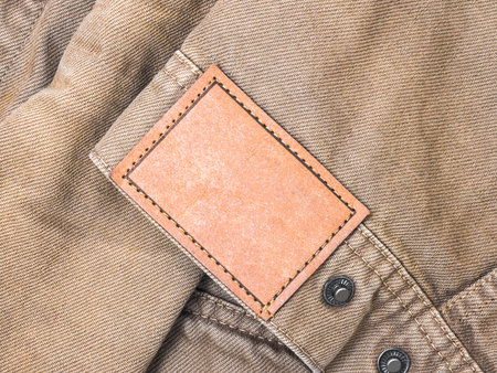 Blank label on brown fabric texture background with copy space.