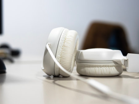 wired headphones close up on a desk with monitors on background.の写真素材