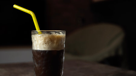 close up view of homemade iced coffee with straw. shallow depth of field
