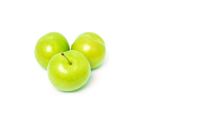 pair of fresh green plums on white background. copy space.の写真素材