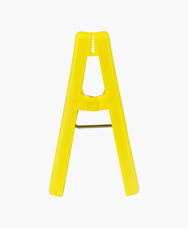 A vibrant yellow clothespin stands uprightの写真素材