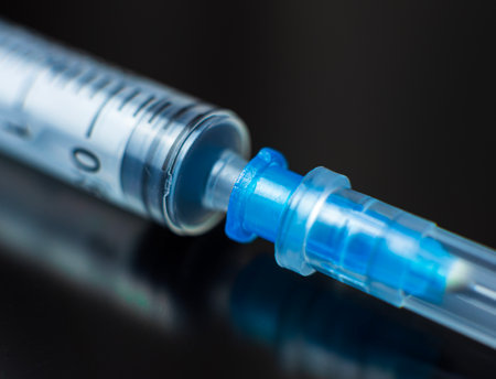 empty syringe positioned on a dark surface. High quality photoの写真素材