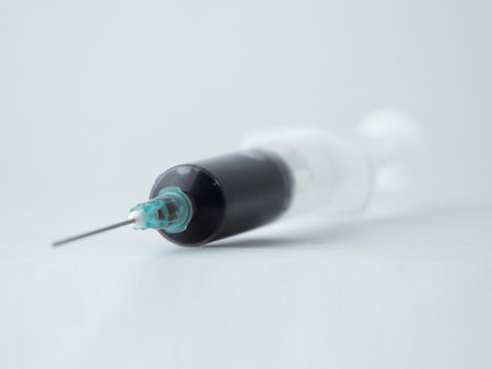A close-up view of a medical syringe filled with blood isolatedの写真素材