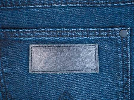 Close-up view of denim fabric highlighting texture and label area for customizationの写真素材