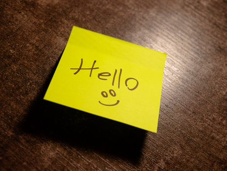 Bright yellow sticky note displays a cheerful hello and a smiley faceの写真素材