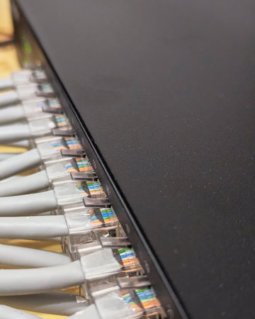 Network cables are neatly arranged, connecting to a switch panel indoors.