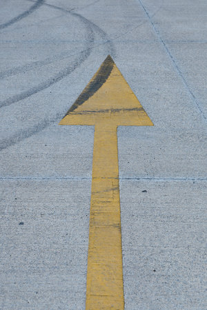 Dark tire marks on a concrete parking area depict skidding and drifting actions