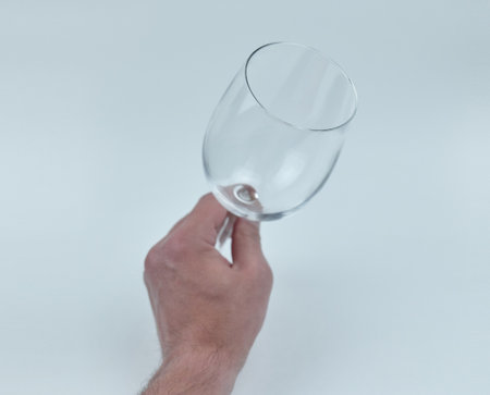 Hand holding a clear glass in an empty spaceの写真素材