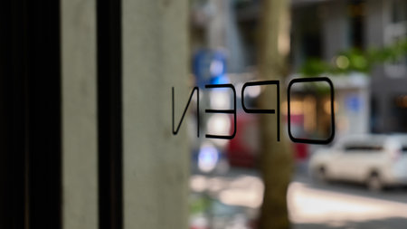 Storefront with open sign visible in a bustling city streetの写真素材