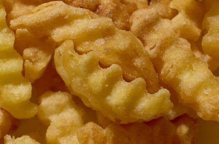 Delicious golden crinkle cut fries ready for eatingの写真素材