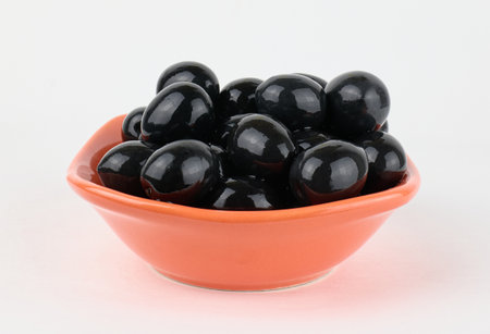 Juicy black olives neatly arranged in a bowlの写真素材